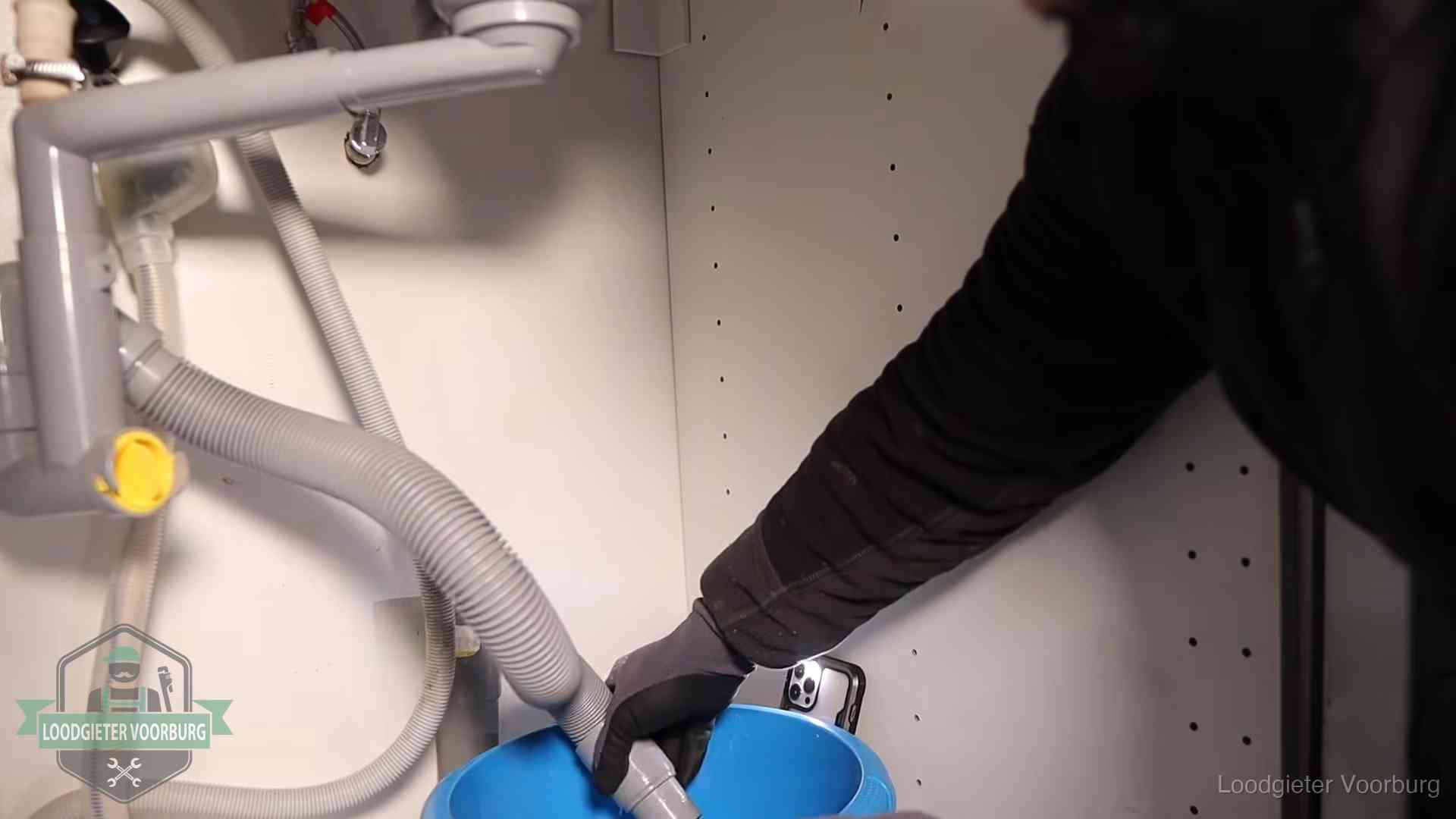 Afvoerslang loopt leeg in een emmer onder de gootsteen in Voorburg, een klus die je zelf kunt doen