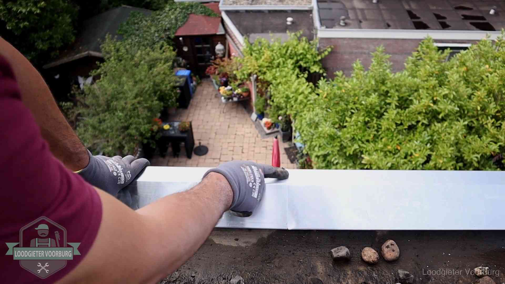 Daklekkage geregeld in Voorburg Vakman plaatst een daktrim op de dakrand van een woning in Voorburg