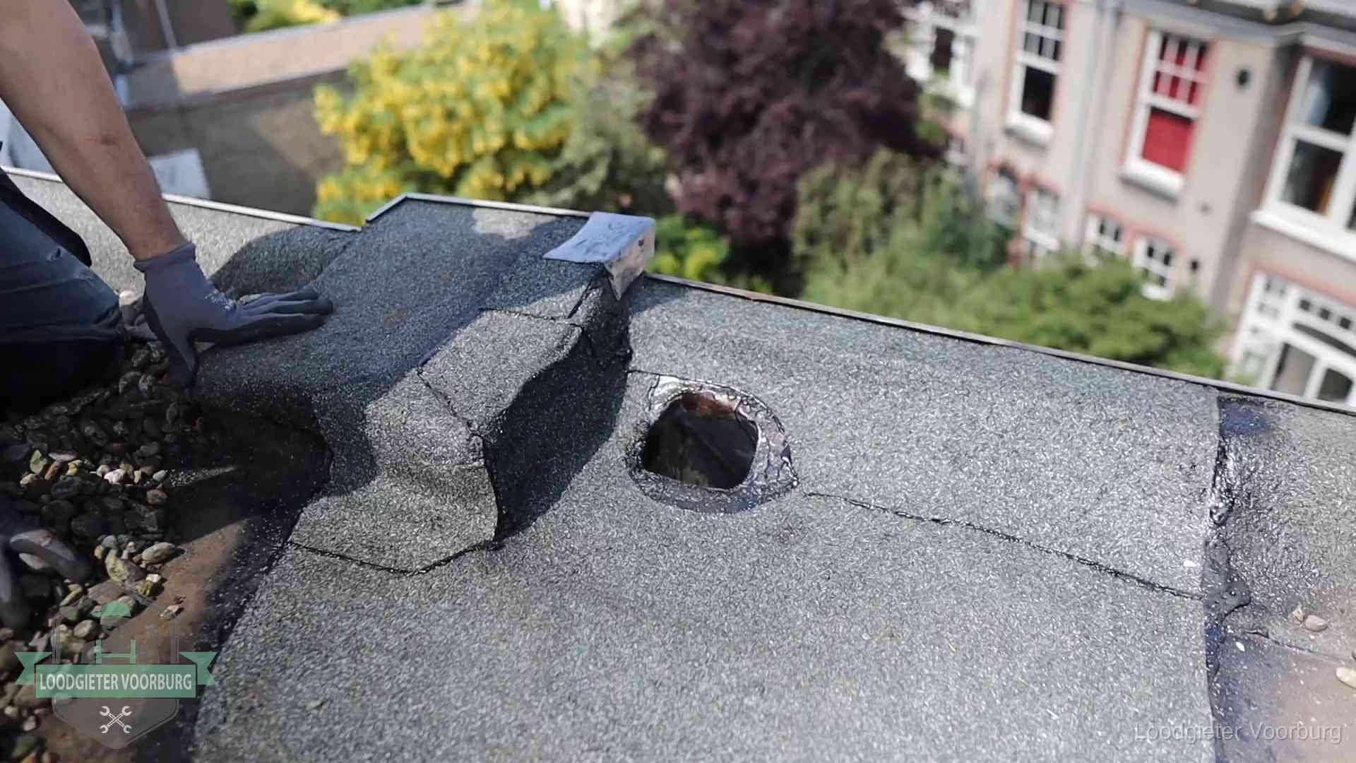 Daklekkage-inspectie op een plat dak in Voorburg Loodgieter inspecteert een beschadigd bitumen plat dak tijdens een daklekkage-inspectie in Voorburg