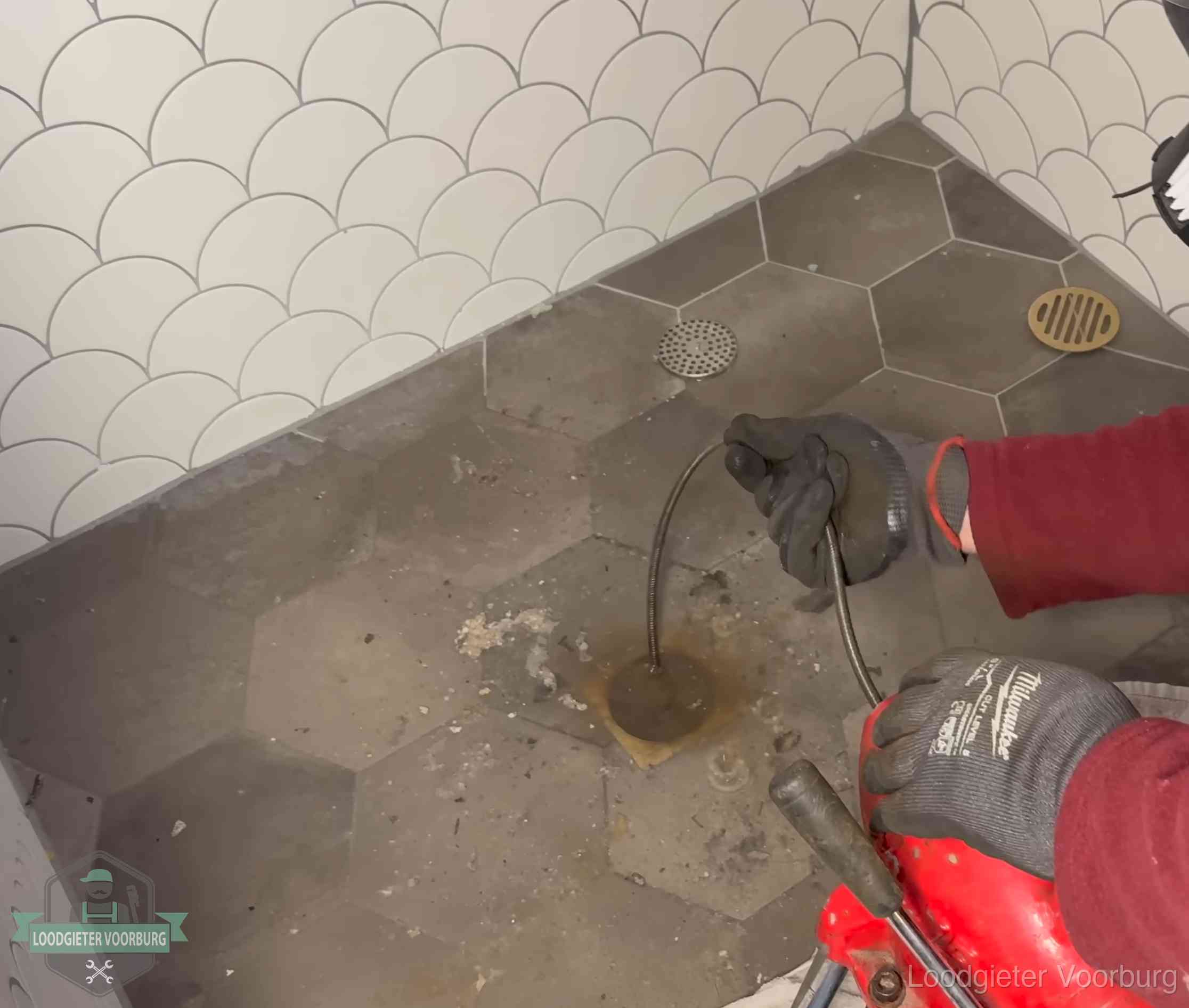 Ontstoppingsveer gaat in een geopend doucheputje in Voorburg waar het water omhoogkwam