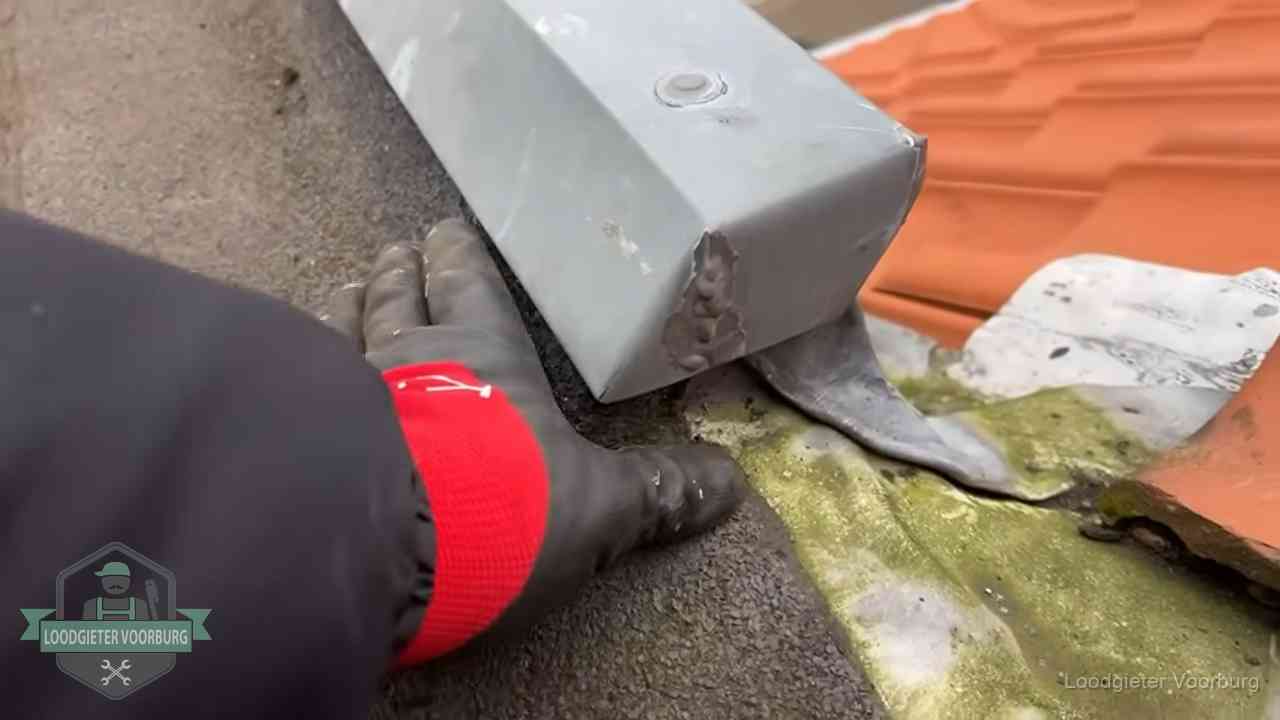 Hemelwaterafvoer en dakgoot controleren in Voorburg Controle van een zinken hemelwaterafvoer met loodslab bij dakpannen in Voorburg