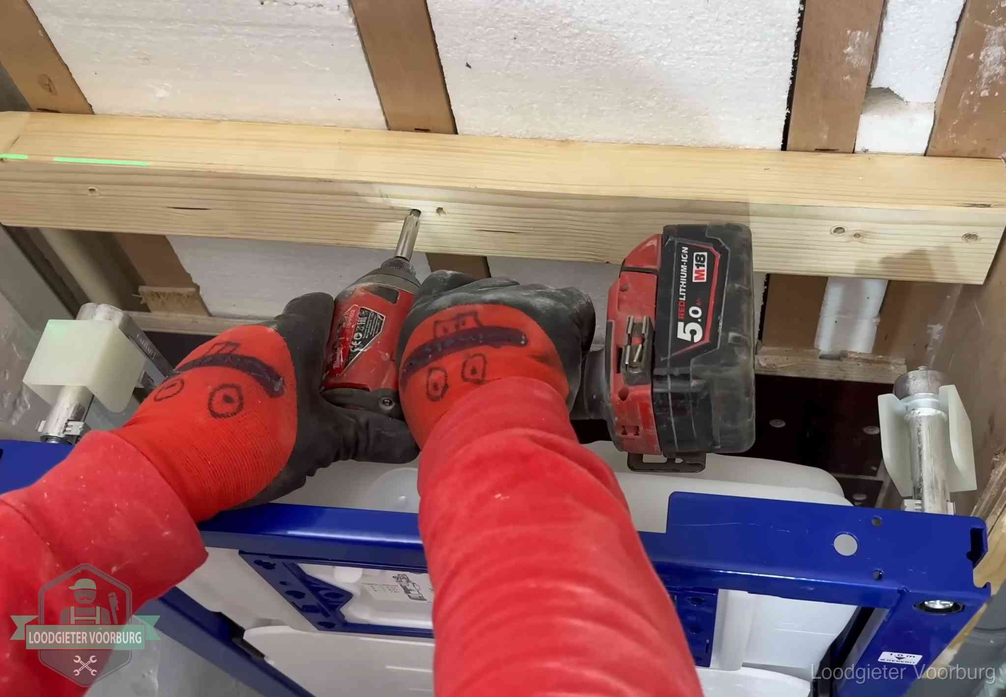 Monteur bevestigt een inbouwreservoir voor een hangend toilet in Voorburg