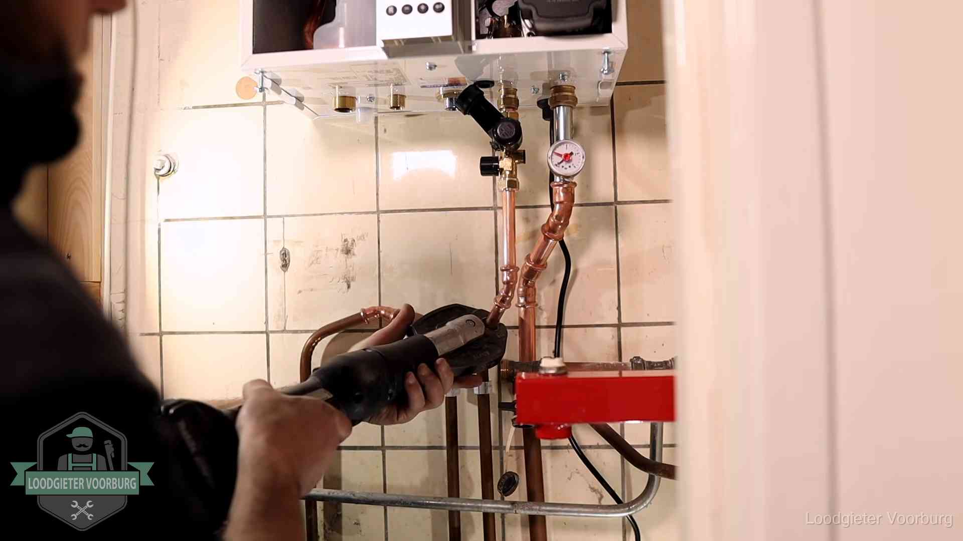 Cv-ketel onderhoud in Voorburg Monteur werkt aan de leidingen onder een cv-ketel in Voorburg