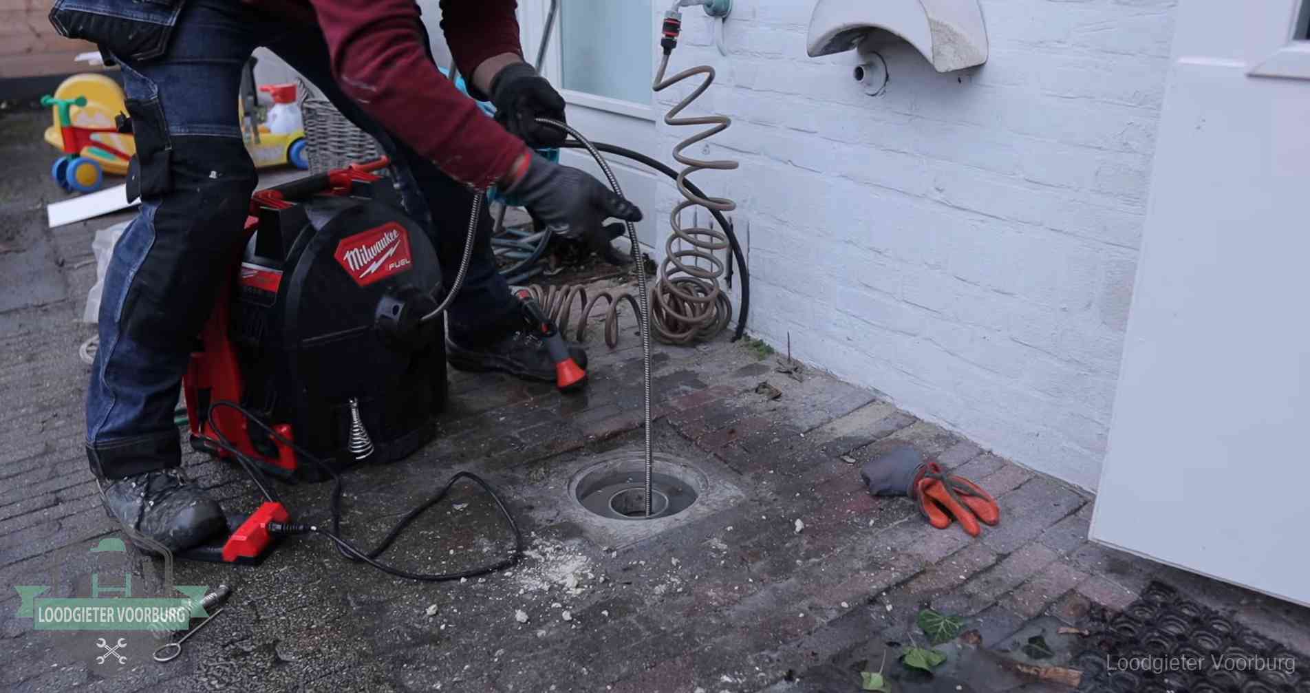 Ontstoppingsputje in de bestrating naast de gevel van een woning in Voorburg