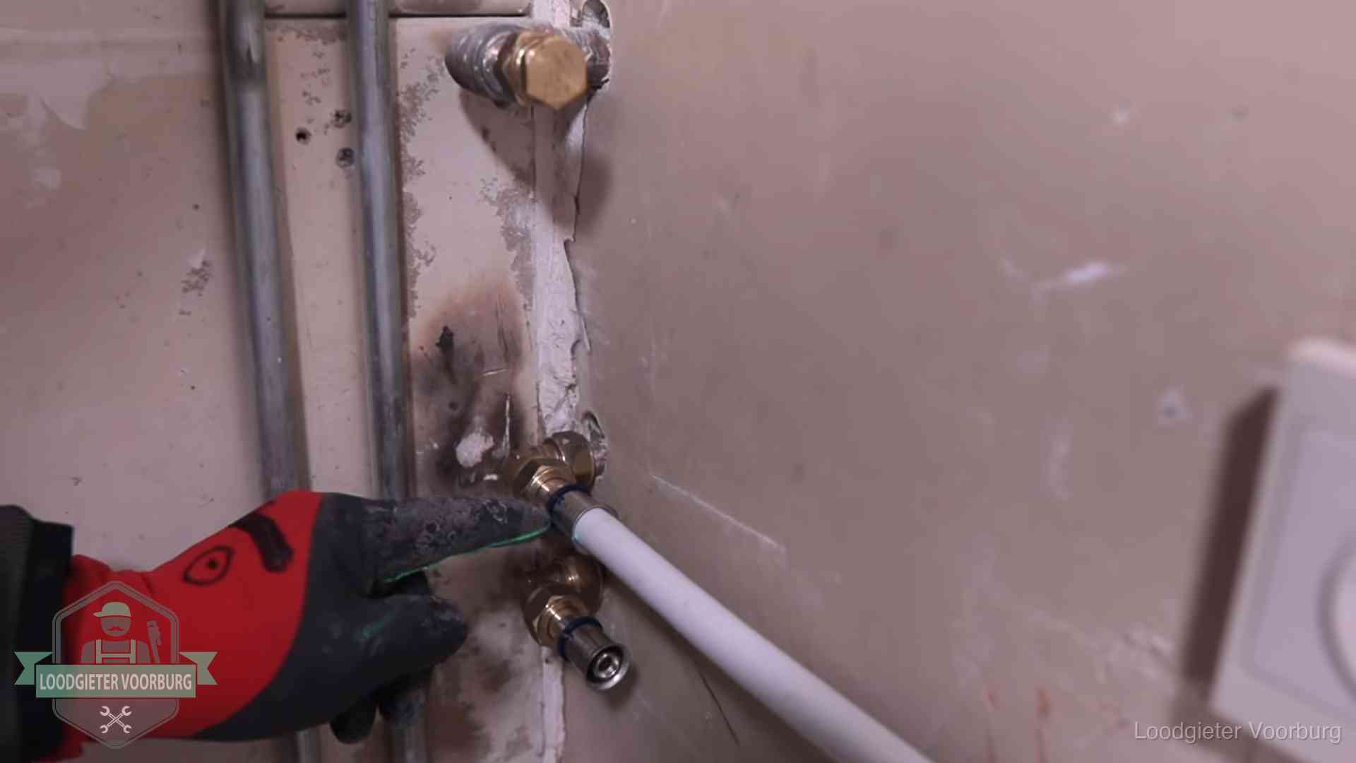 Garantie op loodgieterswerk in Voorburg Loodgieter wijst de persfitting op nieuwe muuraansluitingen aan in een woning in Voorburg