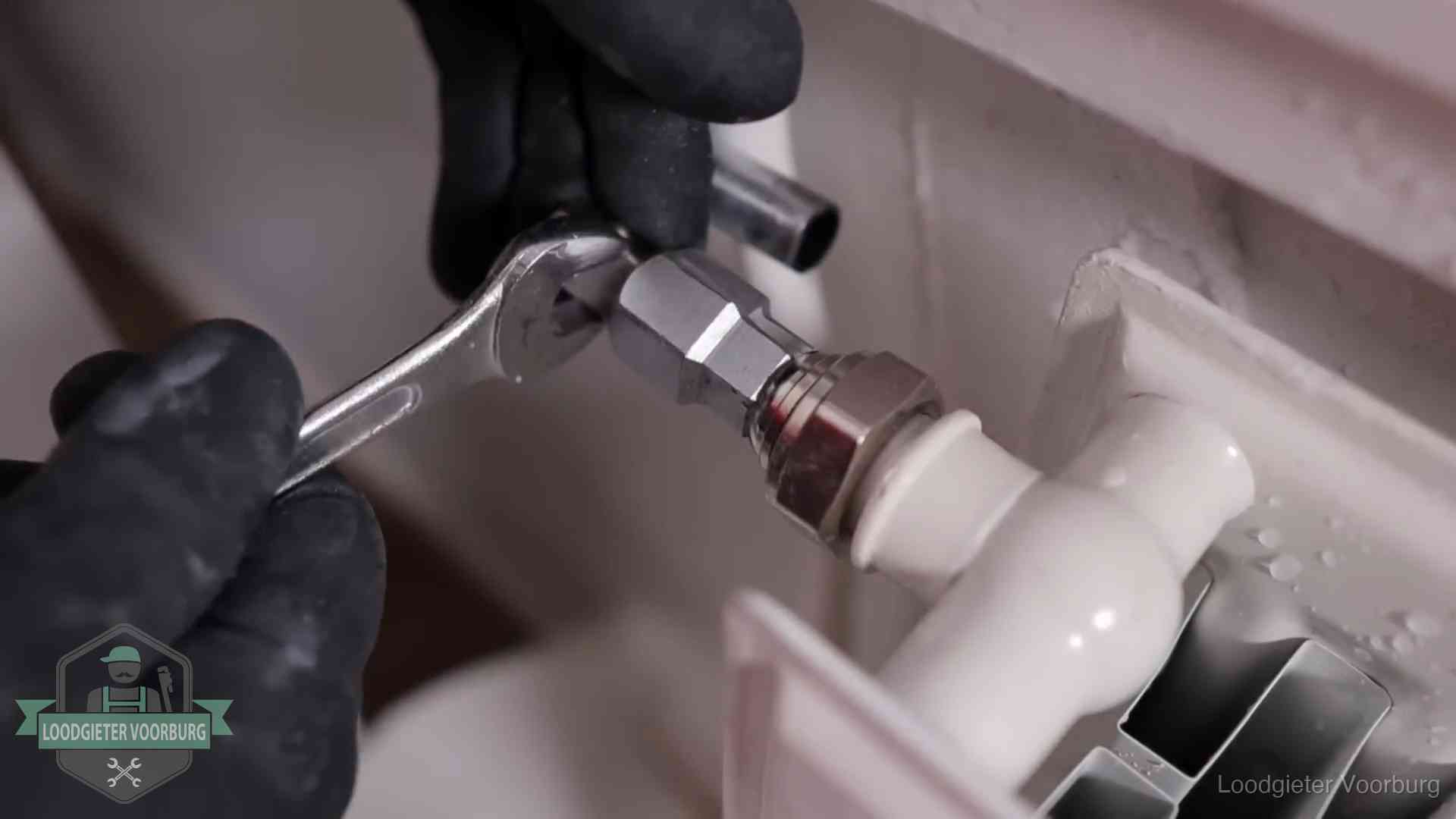 Radiatoren en waterzijdig inregelen in Voorburg Steeksleutel draait een wartelkoppeling op een radiatorkraan aan in Voorburg