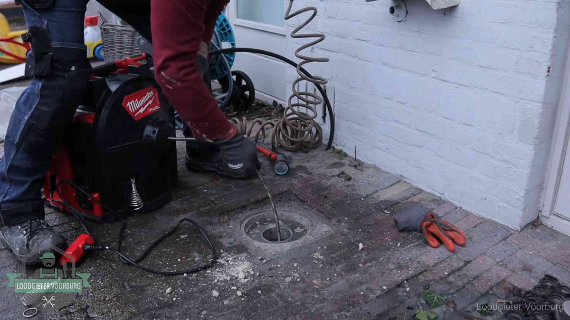 Spiraalmachine bij een ontstoppingsputje in de bestrating in Voorburg