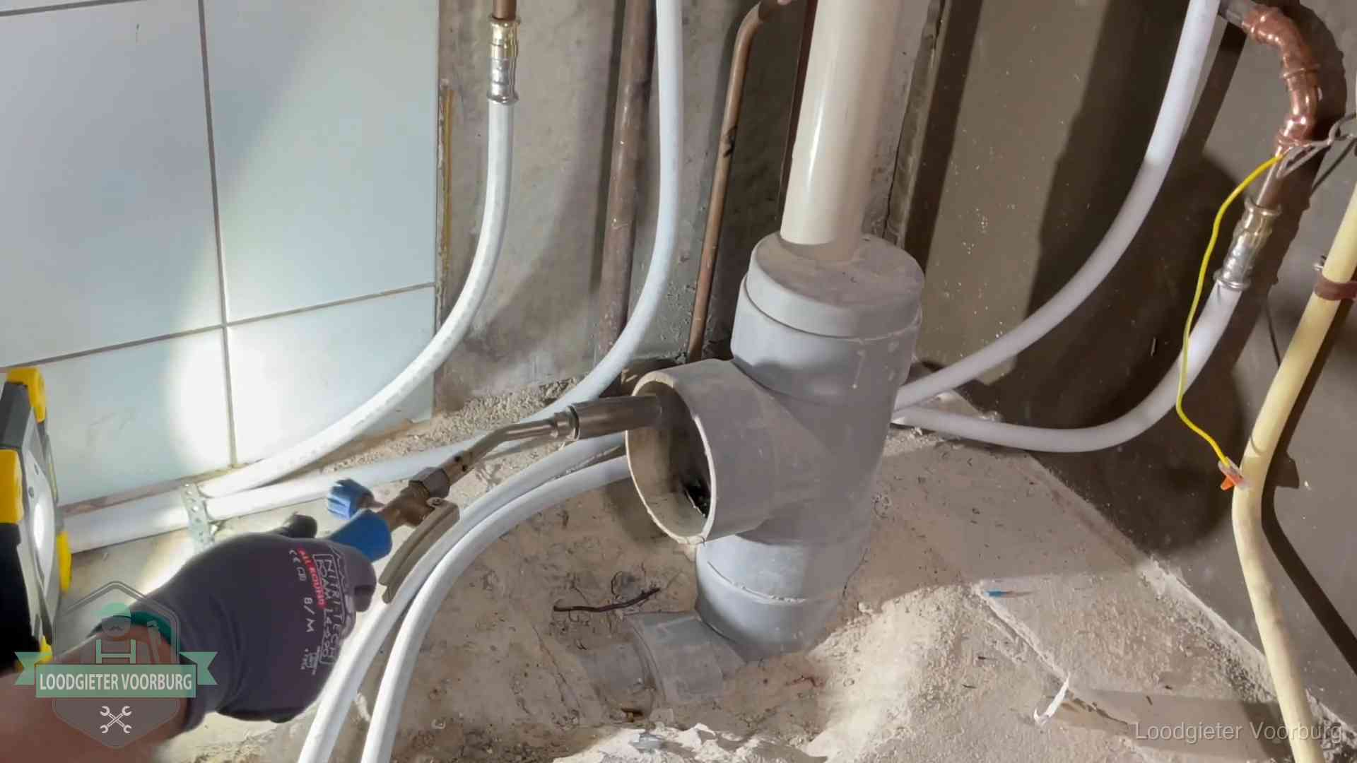 Loodgieter werkt aan leidingen bij de pvc-standleiding van een huurwoning in Voorburg