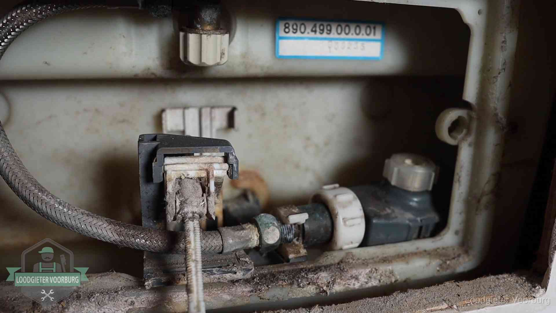 Verkalkt binnenwerk van een stortbak met vlotterkraan in Voorburg