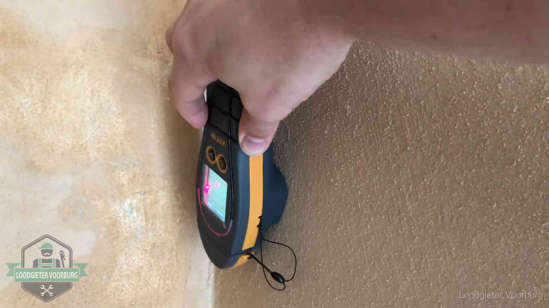 Daklekkage opsporen zonder hakwerk in Voorburg Vochtmeter tegen een muur met vochtplekken tijdens het opsporen van een daklekkage in Voorburg