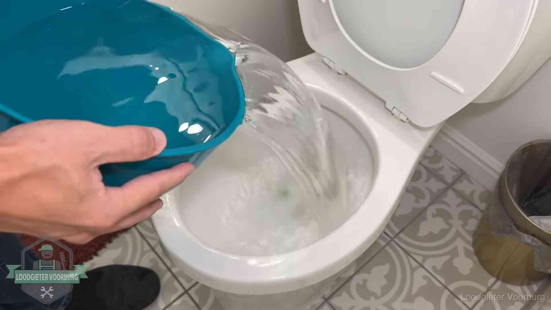 Warm water wordt voorzichtig in de wc-pot gegoten in Voorburg