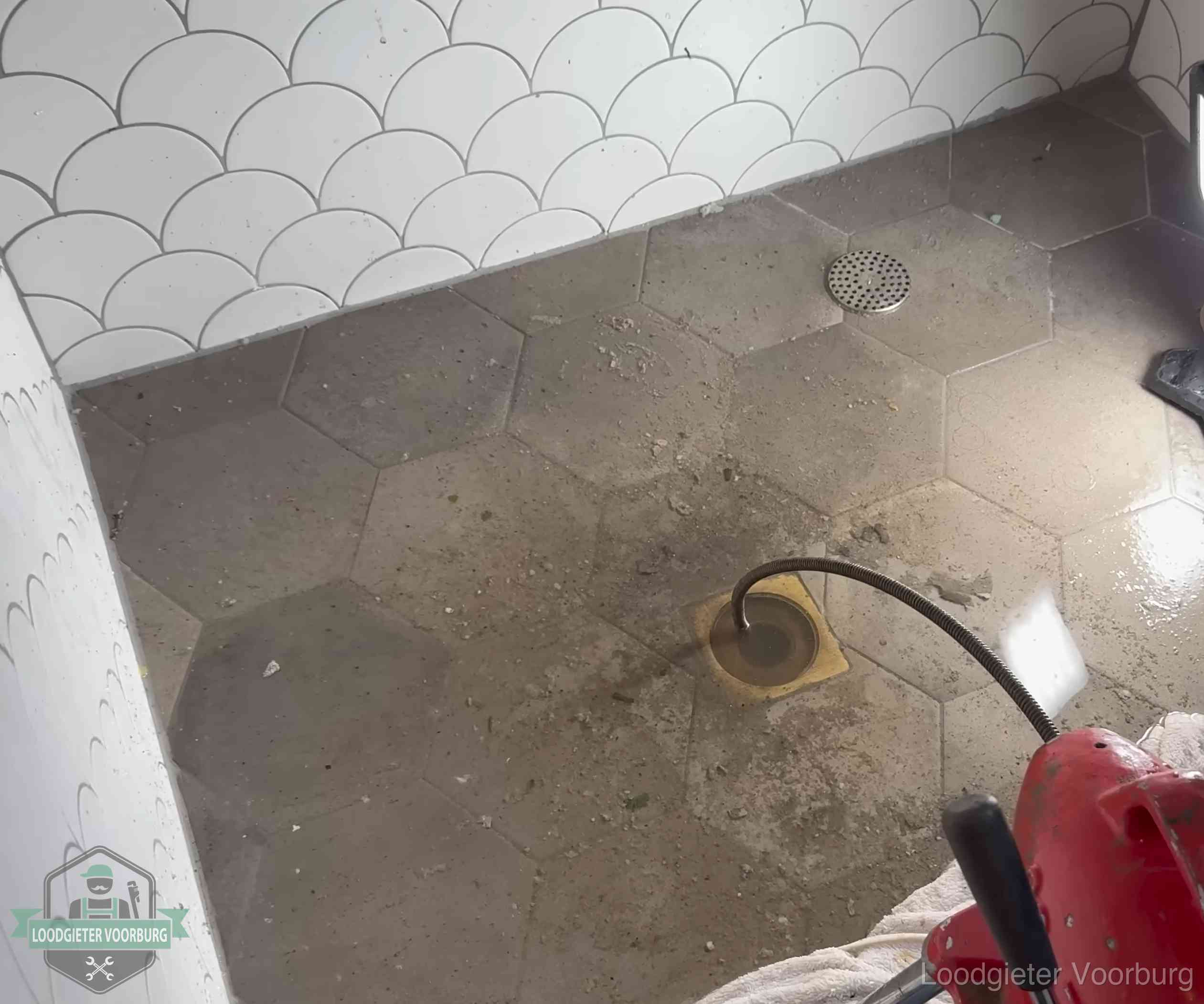 Vloerput met waterslot in een badkamer in Voorburg, een bron van stank als het waterslot droogstaat