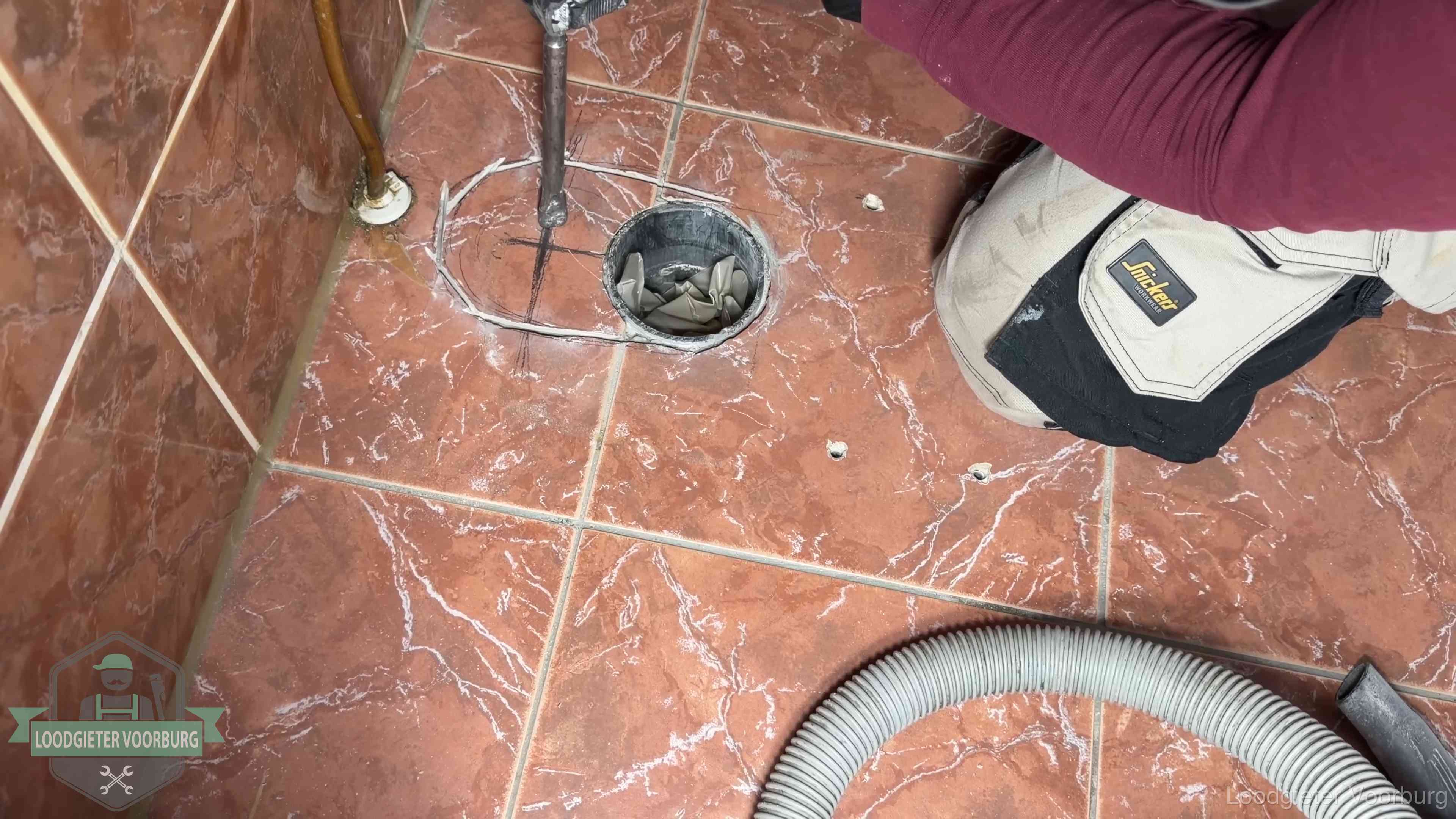 Open rioolaansluiting in de vloer waar de wc-pot is gedemonteerd in Voorburg