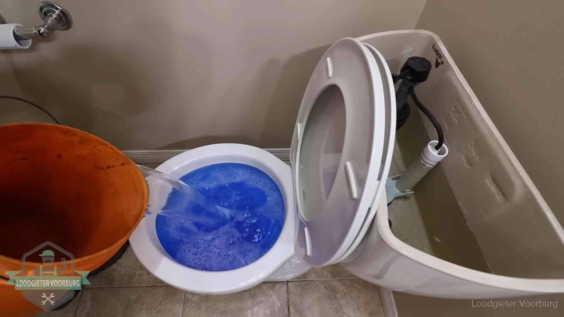 Water bij de wc-pot wordt met een emmer weggewerkt om schade te beperken in Voorburg